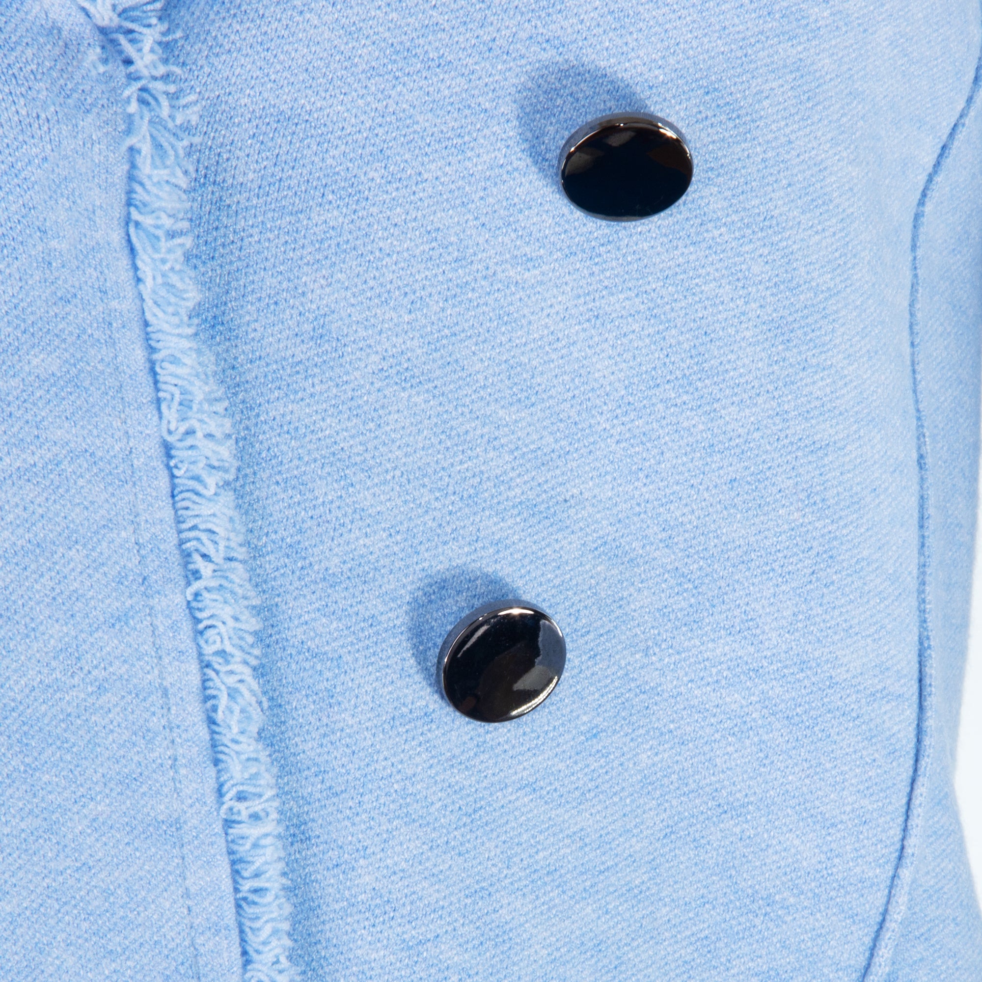 Close-up of a light blue denim jacket with two black buttons.