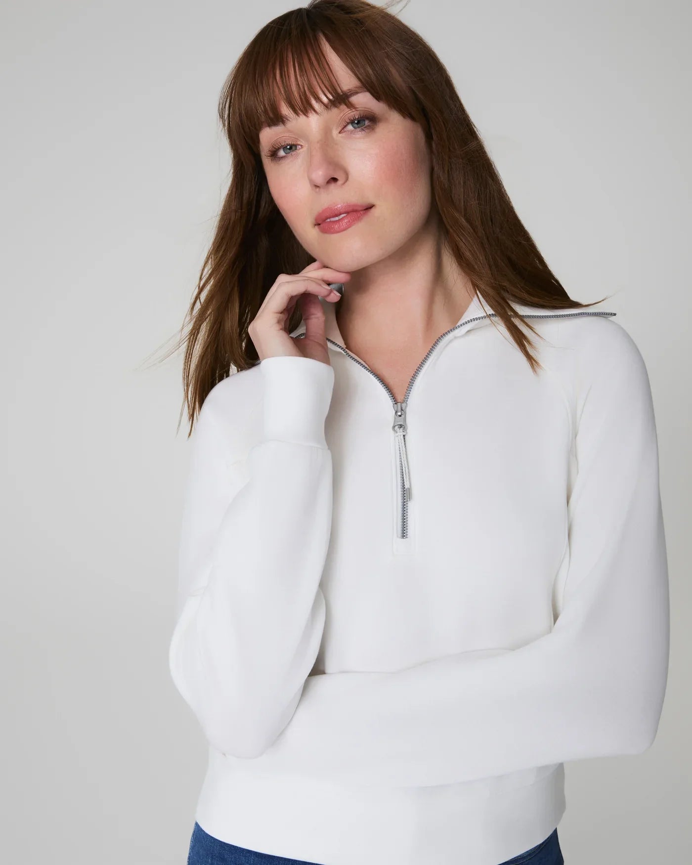 SPANX Airessentials half zip powder jacket showing a sleek, fitted design with a high collar and front zipper.