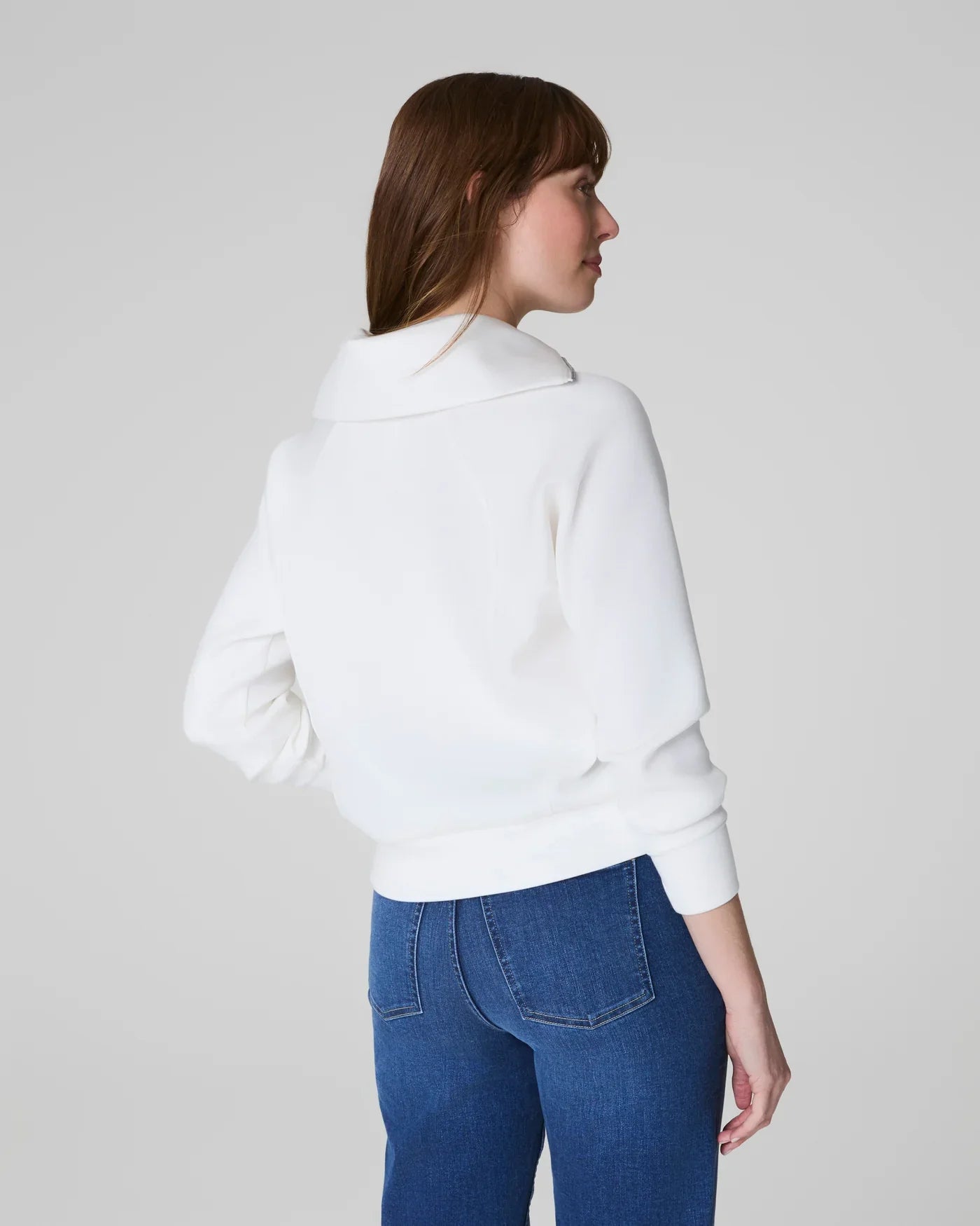 SPANX Airessentials Half Zip Powder jacket showing a stylish, lightweight zip-up jacket in soft powder color with a high collar.