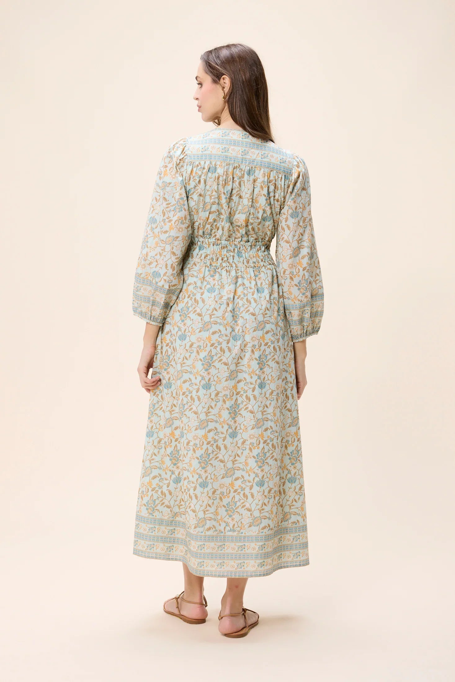 Woman wearing a floral dress on a beige background