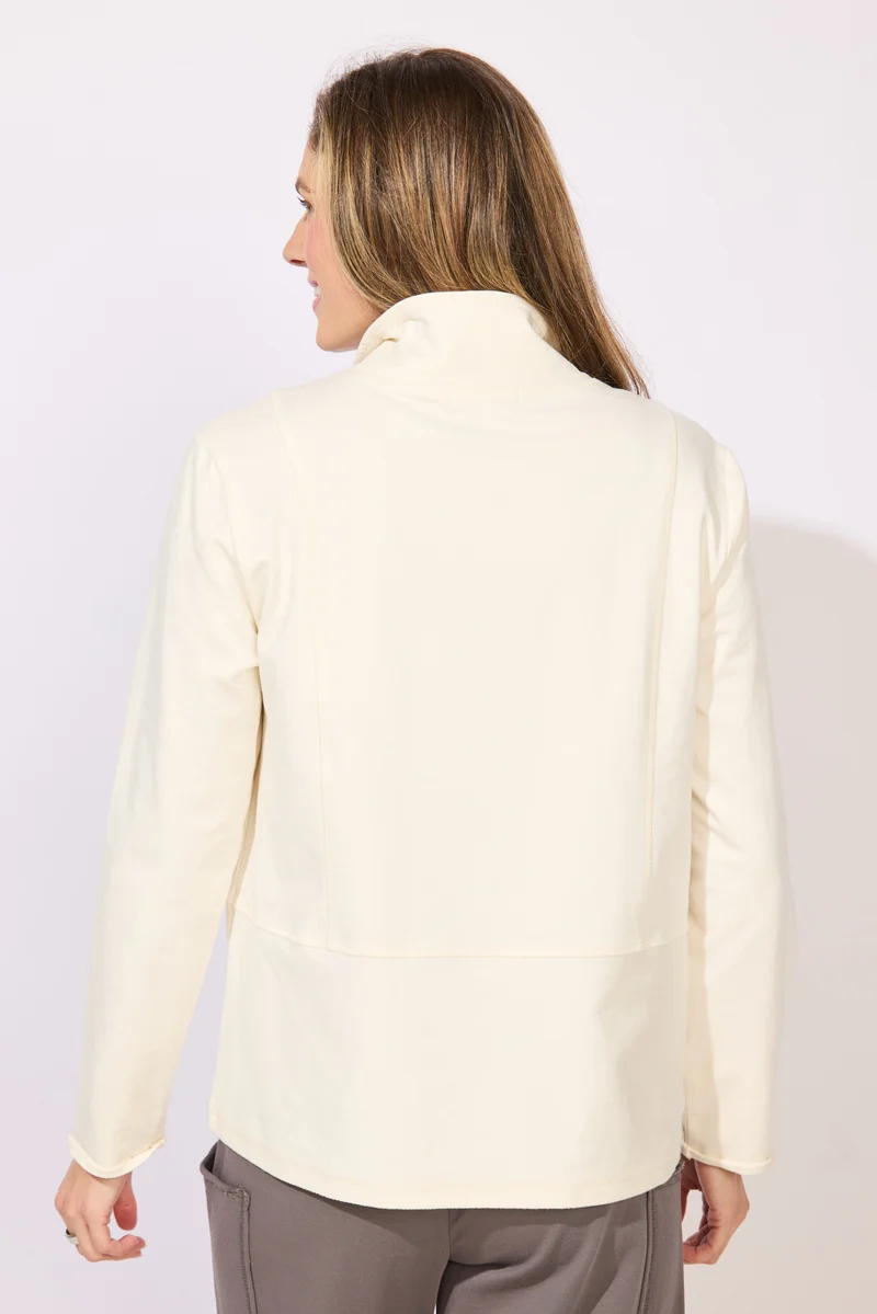 A woman wearing a cream-colored long-sleeve collared top with snap-button details at the collar ESCAPE BY HABITAT OCEAN FRONT TERRY QUARTER SNAP - 30134 Color Pearl