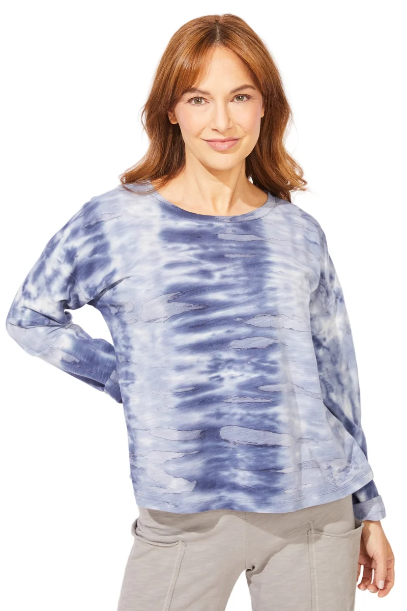 A woman wearing a blue and white tie-dye long-sleeve top ESCAPE BY HABITAT RIVER MODAL SPANDEX SUNSET PULLOVER - 45134 navy