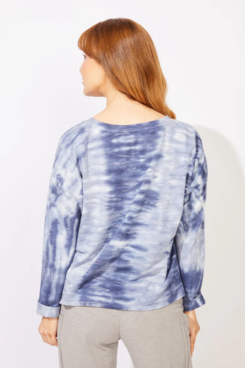 A woman wearing a blue and white tie-dye long-sleeve top ESCAPE BY HABITAT RIVER MODAL SPANDEX SUNSET PULLOVER - 45134 navy