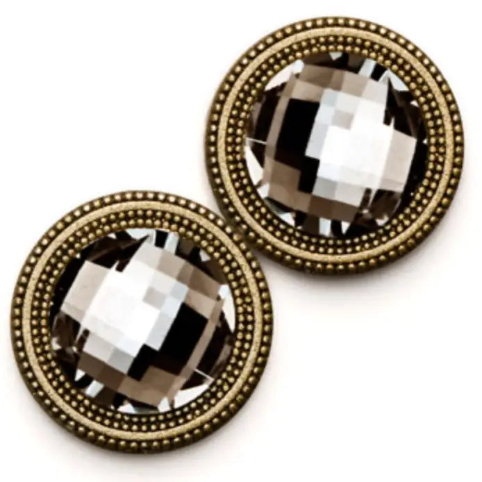 Pair of clothing magnets with gold frames and clear gemstones on a white background