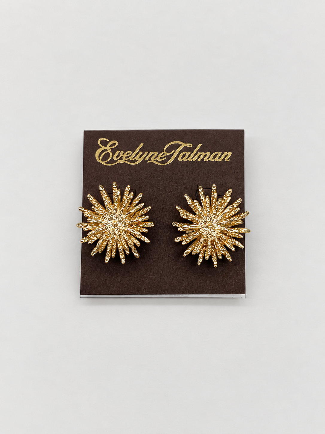 A pair of gold starburst stud clip-on earrings