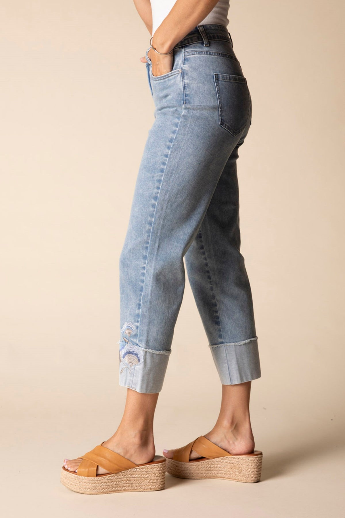 Light blue jeans worn by a person on a beige background