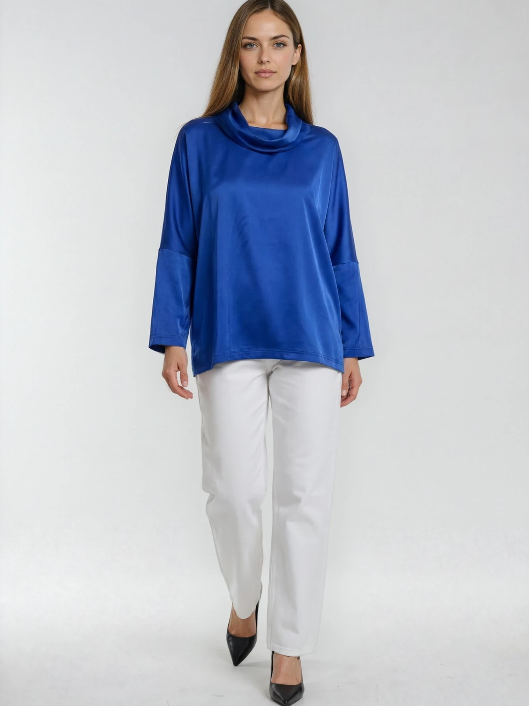Woman wearing a blue top and white pants on a white background