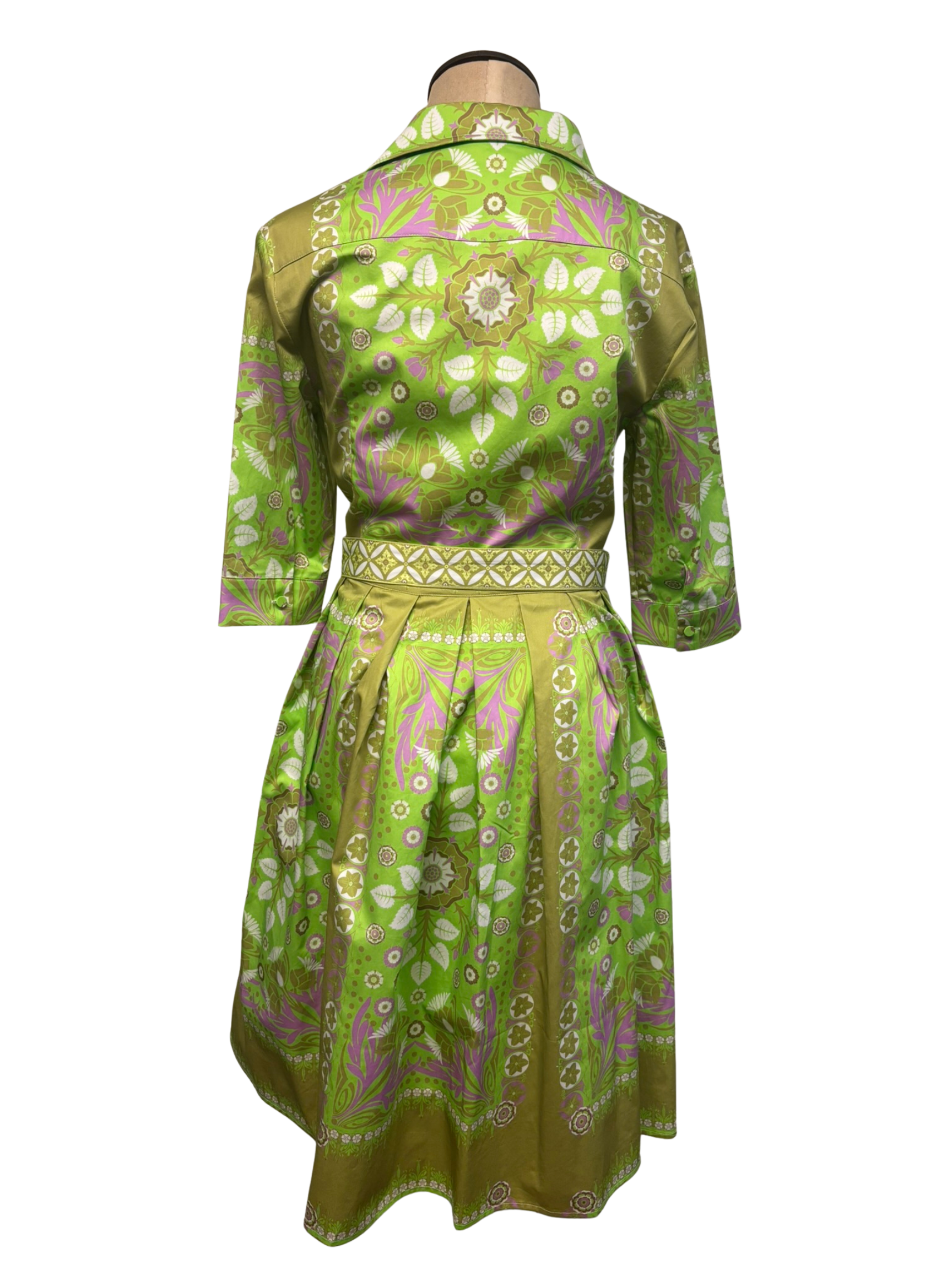 Green patterned dress on a mannequin against a white background