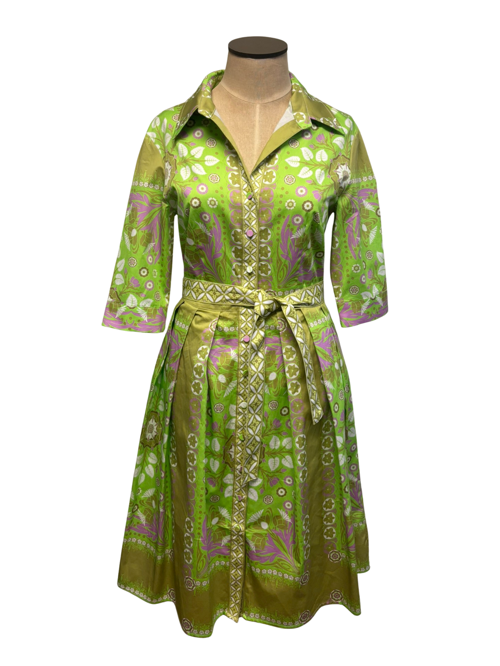 Green patterned dress on a mannequin against a white background