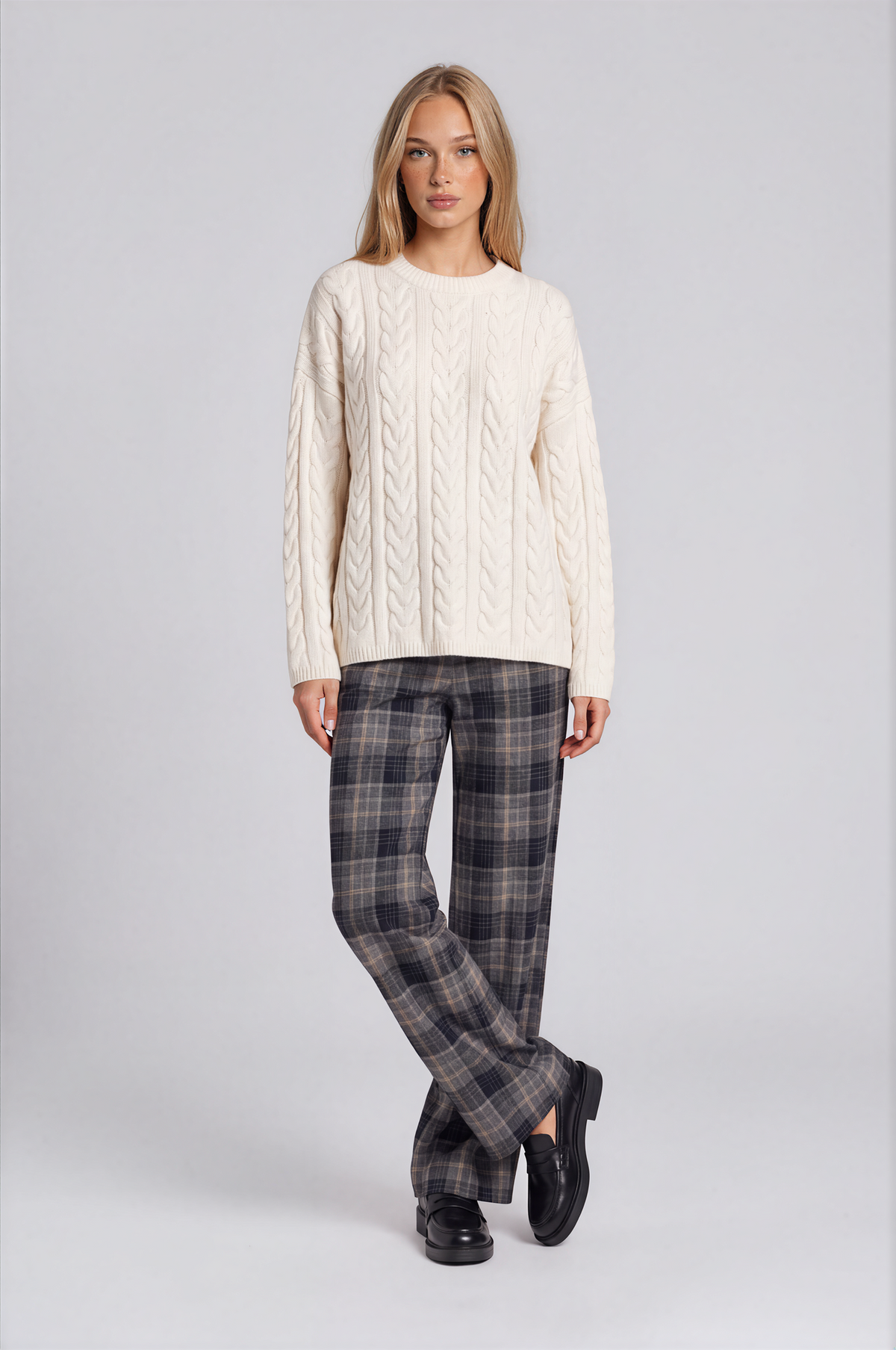 A woman modeling dark gray plaid trousers