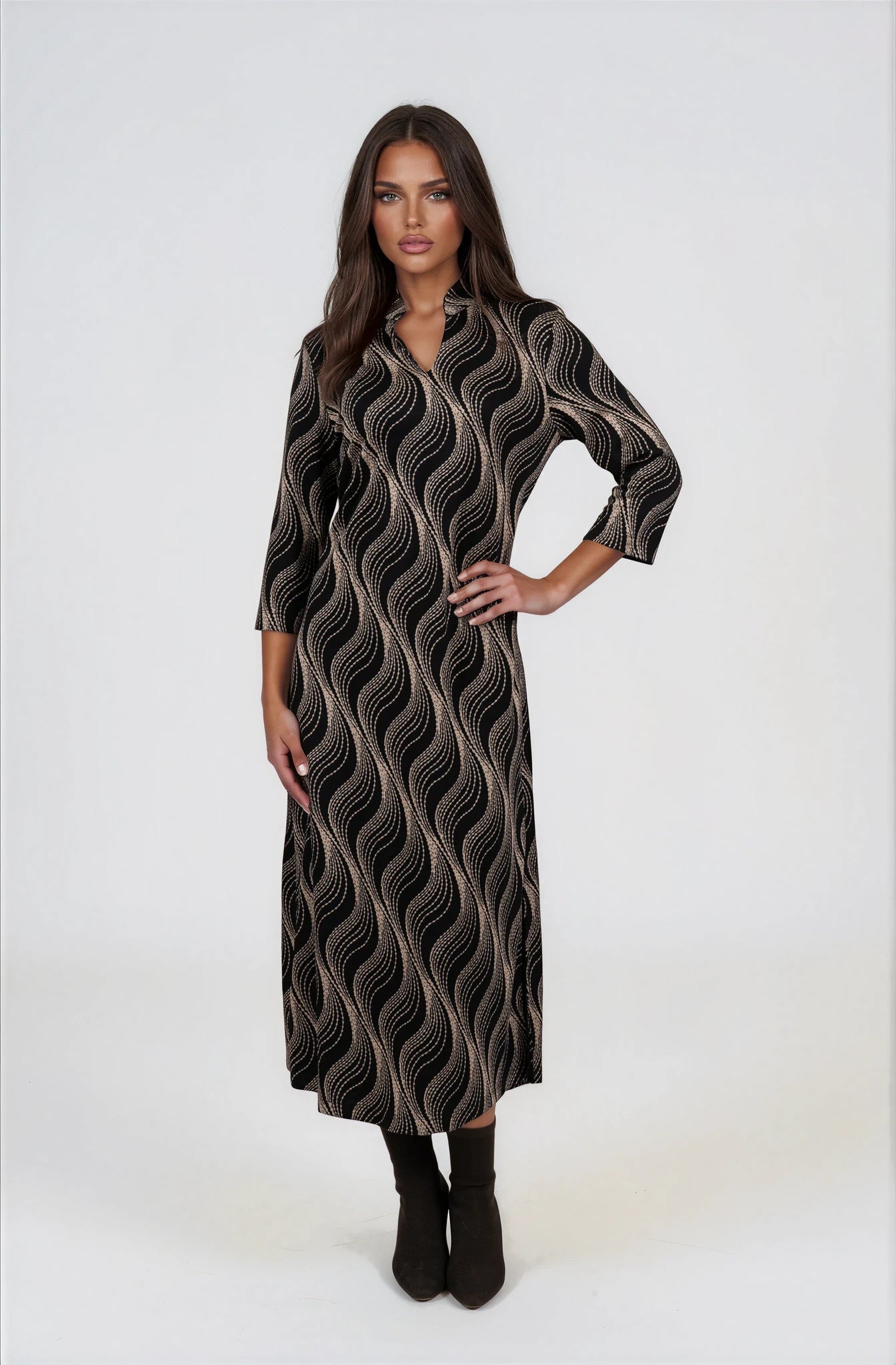 A woman modeling a long-sleeved midi dress with a black base and beige wavy abstract pattern,