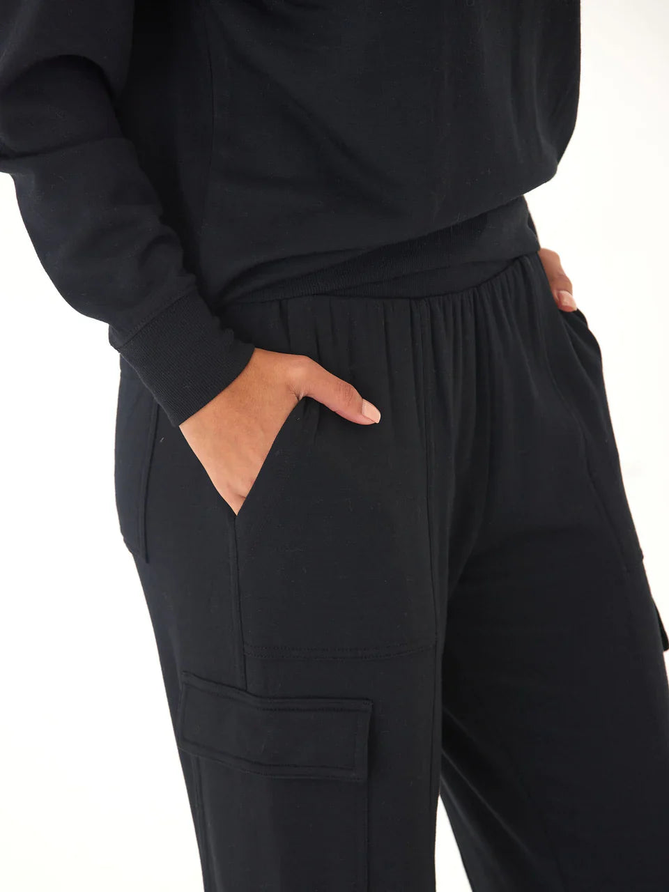 Person wearing black pants with a white background