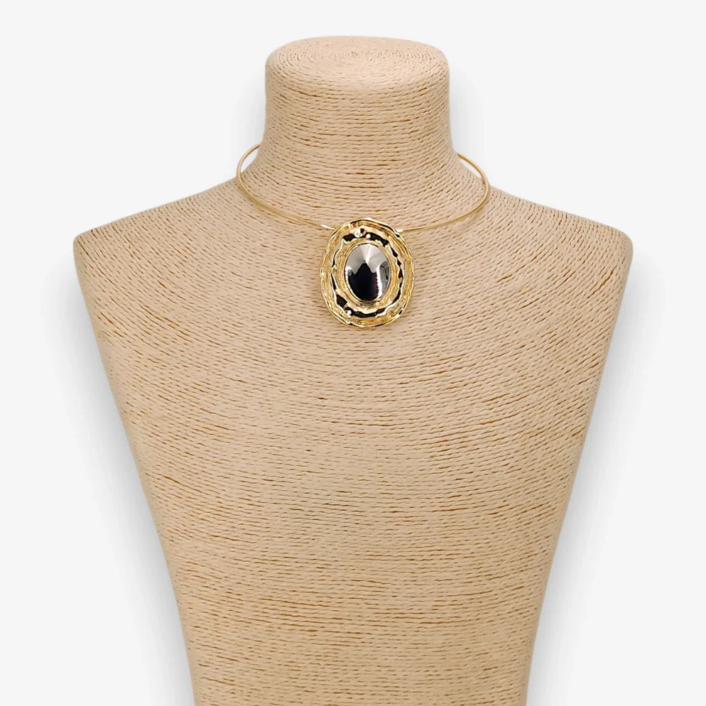 Gold necklace with a large pendant on a mannequin bust against a white background