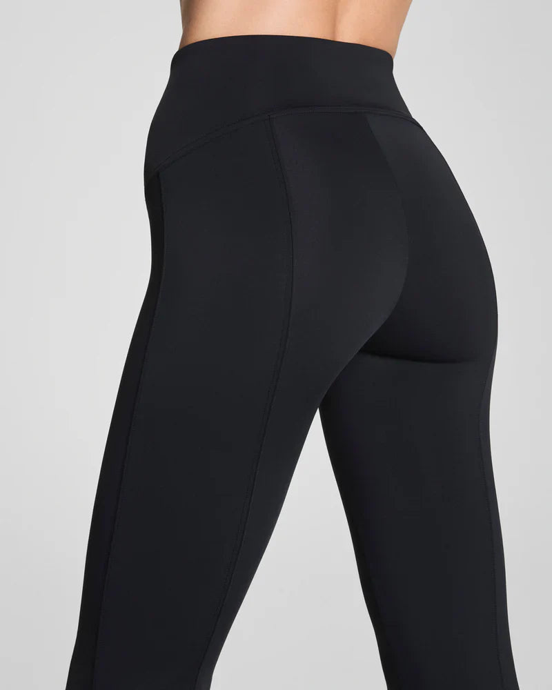 Black SPANX dressy micro flare leggings shown on a model, featuring a fitted style with a subtle flare at the ankle.