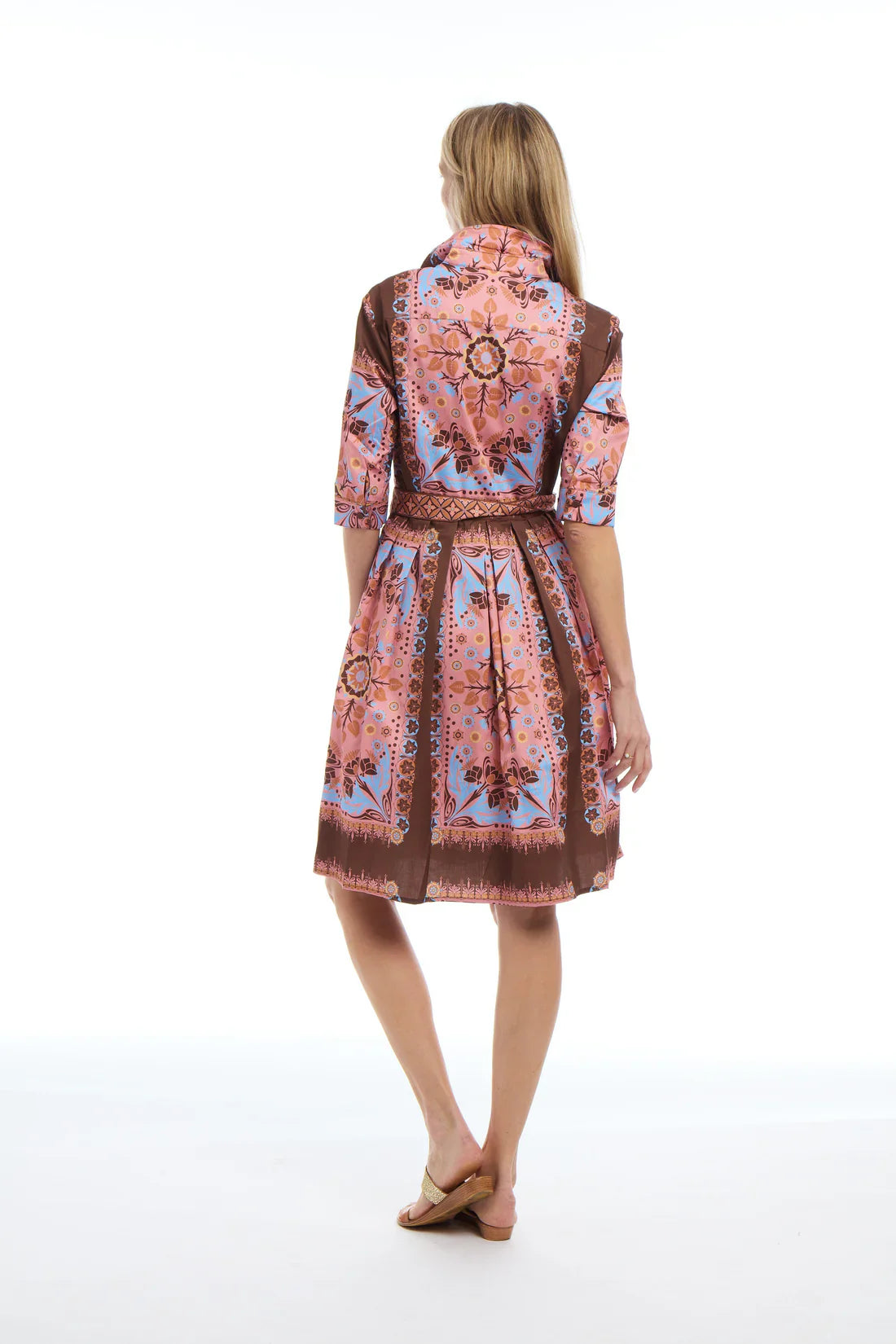 Woman wearing a patterned dress on a white background