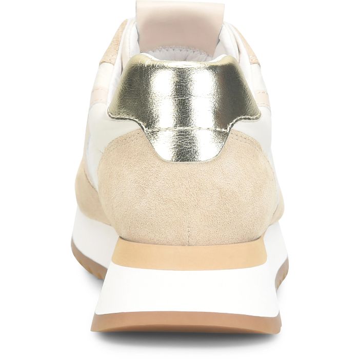 Close-up of a sneaker with gold metallic heel and beige accents on a white background