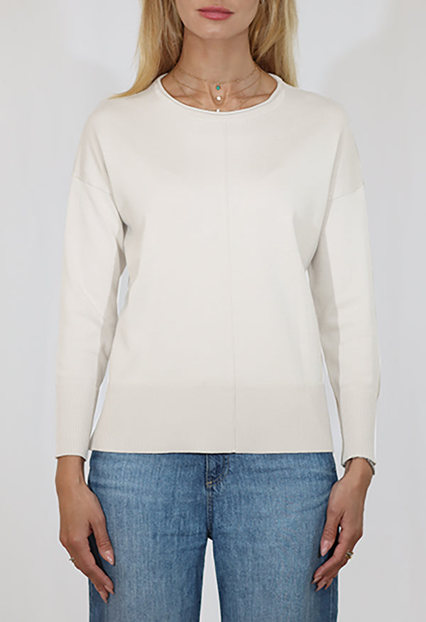 Person wearing a white long-sleeve shirt and blue jeans on a plain background