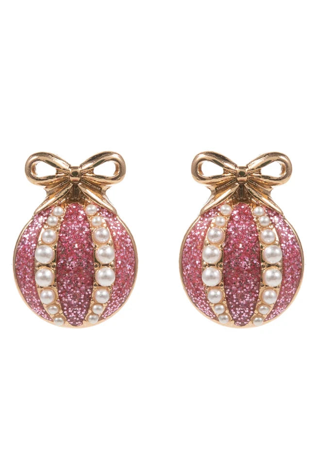 Pink glittery christmas earrings with pearl accents and gold bows on a white background