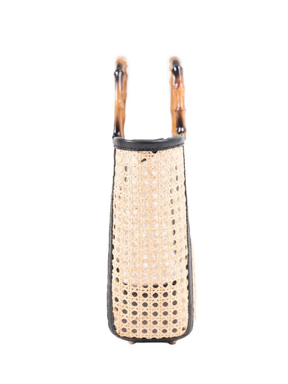 Woven bag with tortoiseshell handles on a white background