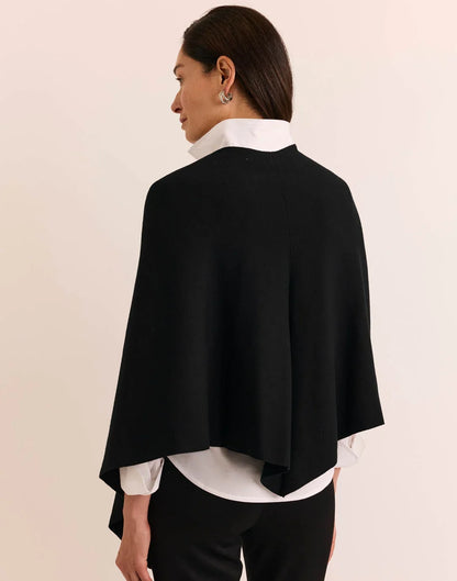A woman modeling a black wrap shawl by  The H Edition Mabel Tab Fringe Wrap
