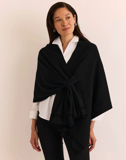A woman modeling a black wrap shawl by  The H Edition Mabel Tab Fringe Wrap