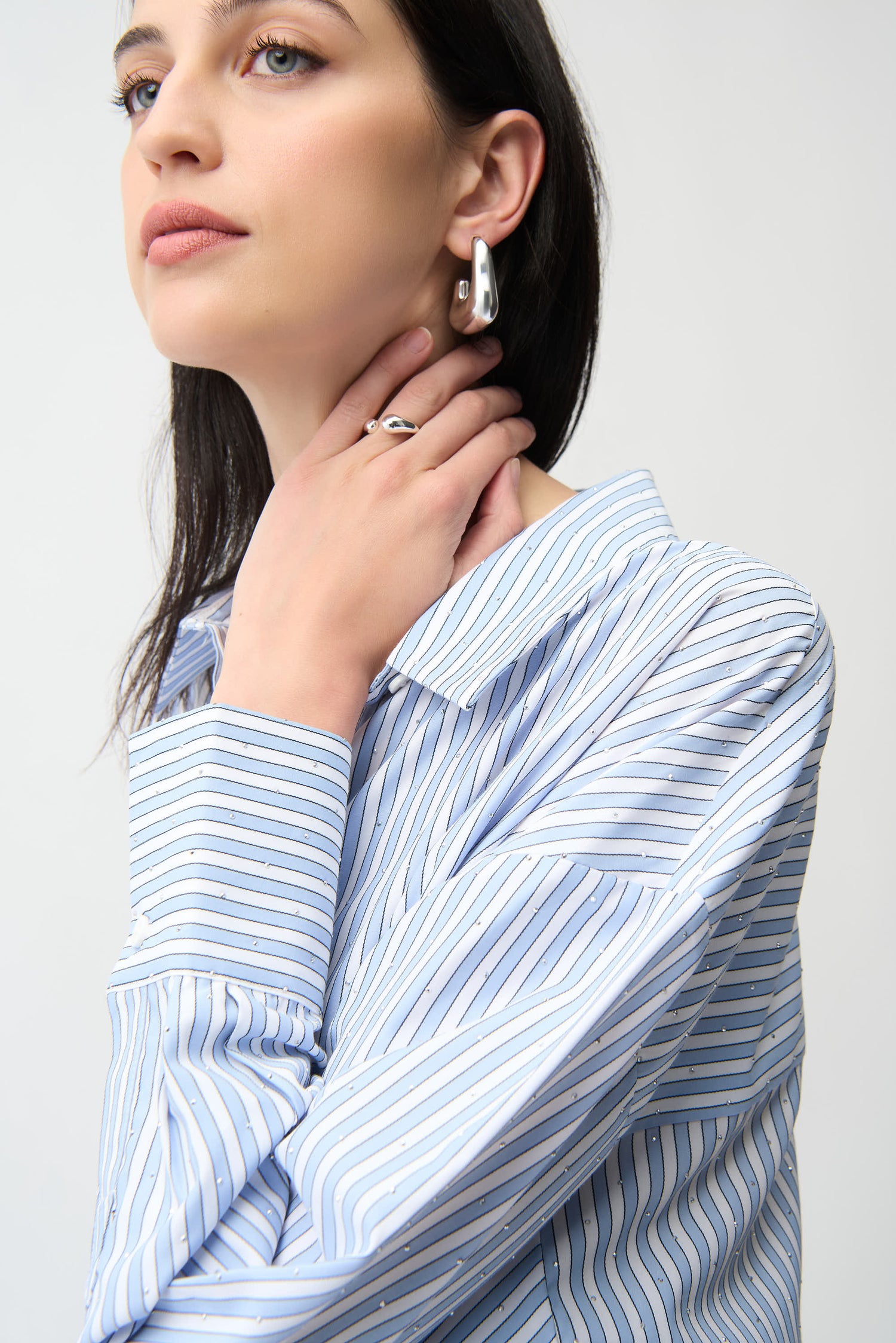 Joseph Ribkoff striped sparkly blouse, long-sleeve tops with shimmering fabric and bold stripe pattern, displayed on a hanger.
