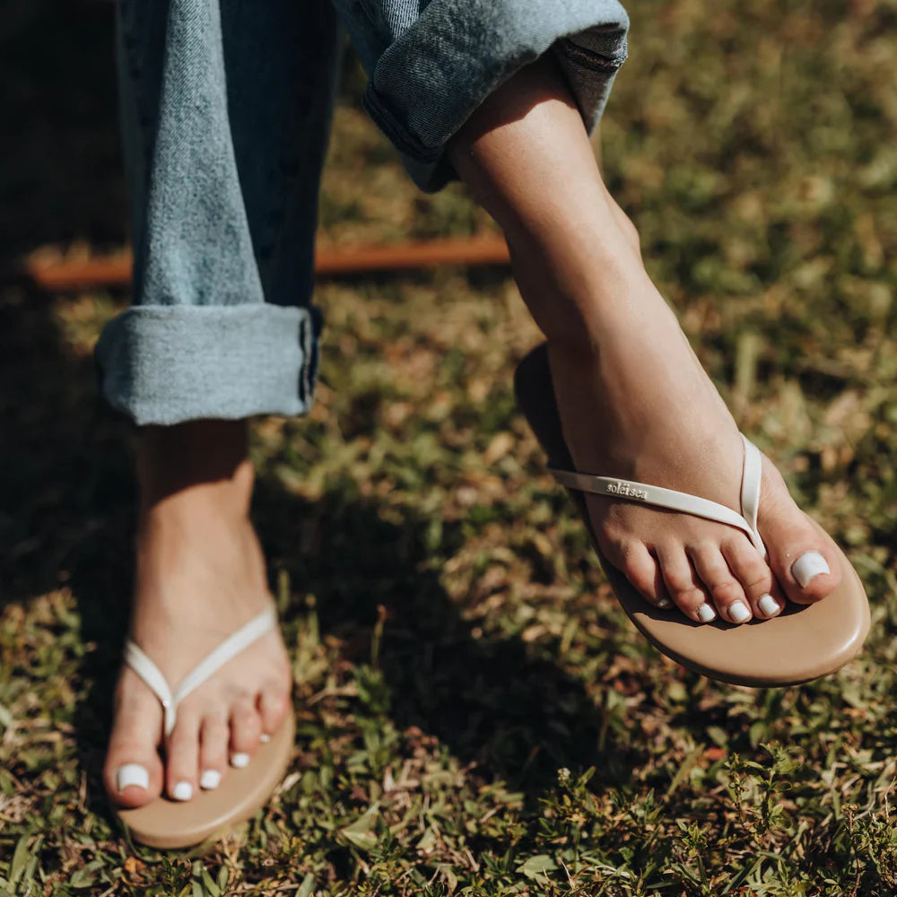 Person wearing beige sandals on grass