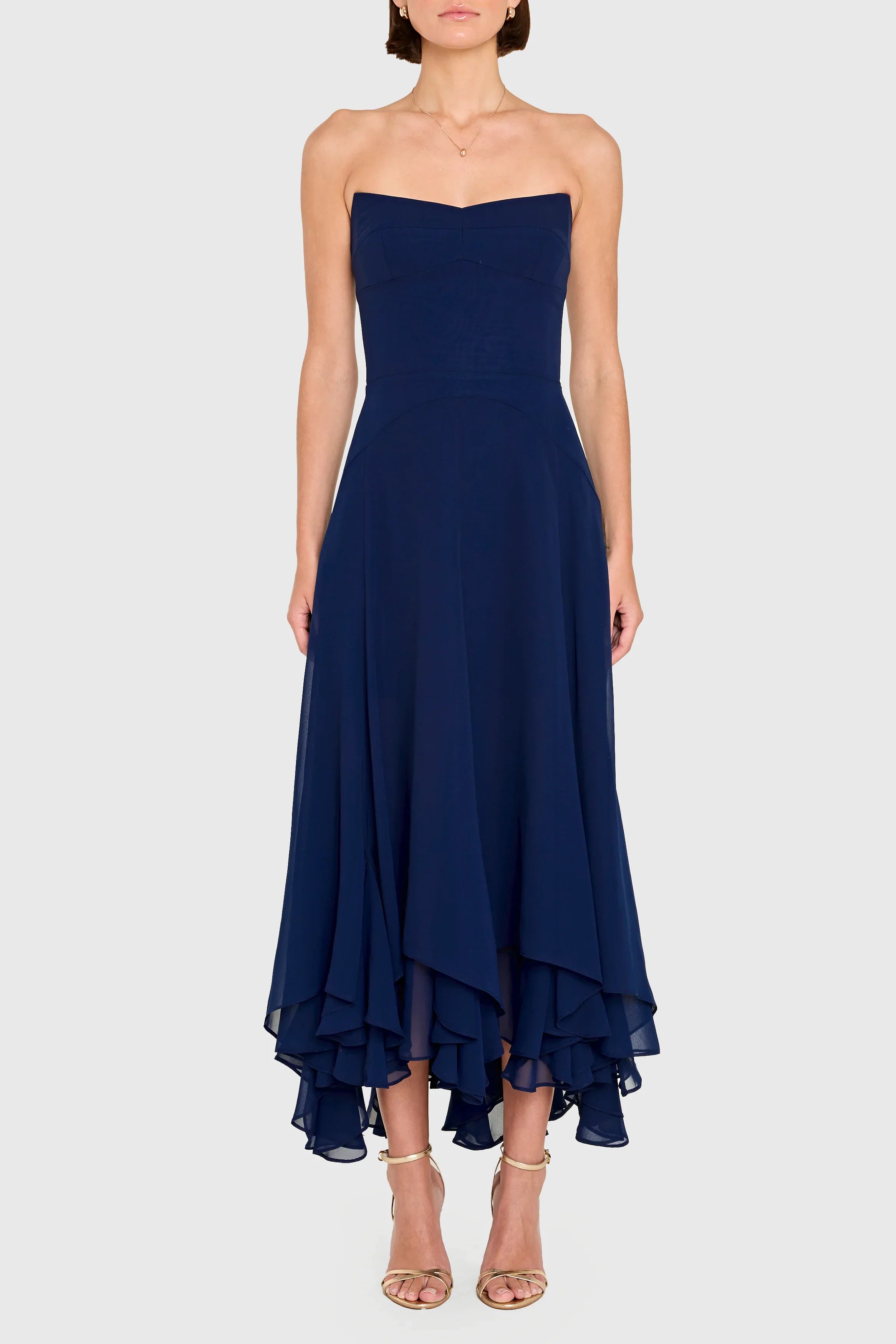 Navy strapless dress with ruffled hem on a white background