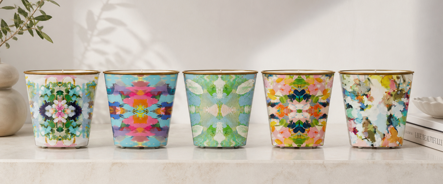 Five floral-patterned candles on a light surface with a neutral background