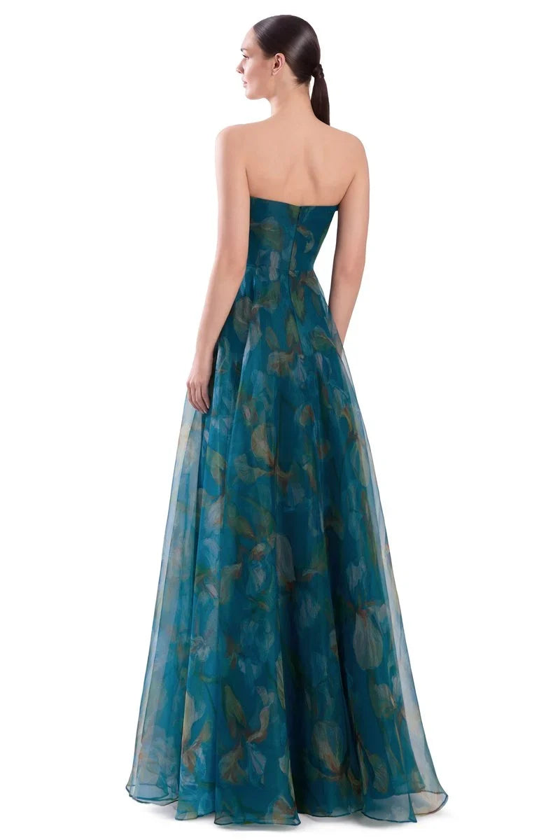A woman modeling a strapless off-the-shoulder floor-length gown in teal blue-green sheer fabric with a subtle tonal floral pattern. Draped 3D Flower Strapless Gown - Alexander by Daymor 3304F26