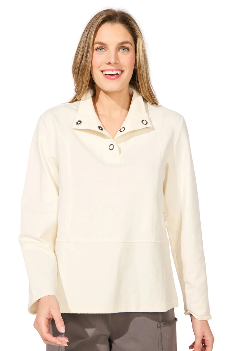 A woman wearing a cream-colored long-sleeve collared top with snap-button details at the collar ESCAPE BY HABITAT  OCEAN FRONT TERRY QUARTER SNAP - 30134 Color Pearl
