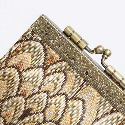 Close-up of a metallic clutch with intricate design and gold accents.