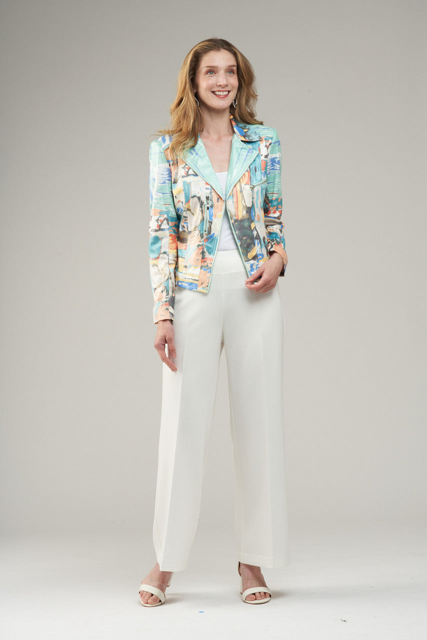 Woman wearing a colorful jacket and white pants on a plain background