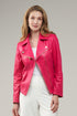 Woman wearing a pink leather jacket against a gray background
