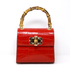 Women’s red handbag with gold  details and bamboo handle 