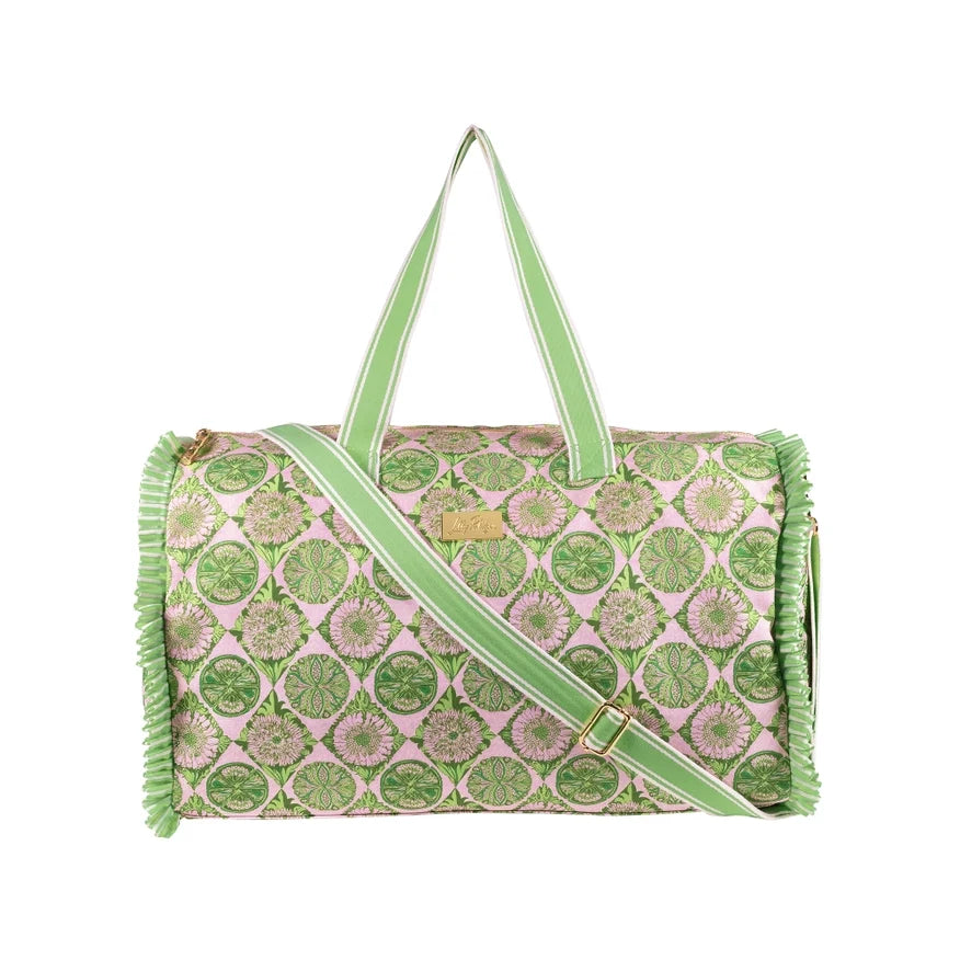 A Lilly Pulitzer Duffle Tote, Tropical Tiles tote bag with a green and pink citrus slice pattern, featuring pale green handles and a small gold-tone Lilly Pulitzer logo plaque. 