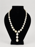 A pearl necklace features irregular white pearls with a central cluster and a teardrop-shaped pearl dangle hanging from a small silver-toned connector.