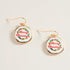 Merry Christmas-themed earrings on a light beige background