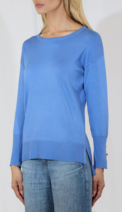 Woman wearing a blue long-sleeve top with a white background