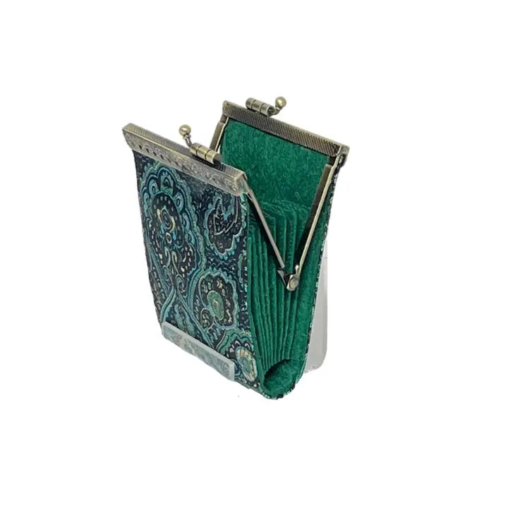 Green fabric clutch with paisley pattern and metal frame on a white background