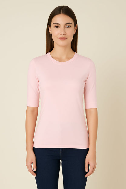 Woman wearing a light pink sweater against a beige background
