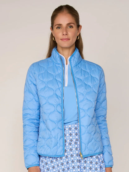 Woman wearing a light blue quilted jacket against a plain background