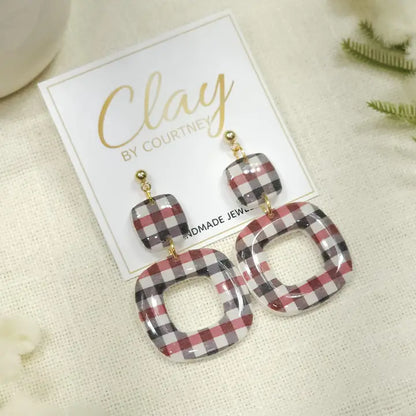 Red Black Gingham Earrings UGA Georgia a pair of square drop earrings with a red, gray, and white plaid pattern, hanging from gold-tone posts on a white display card labeled &