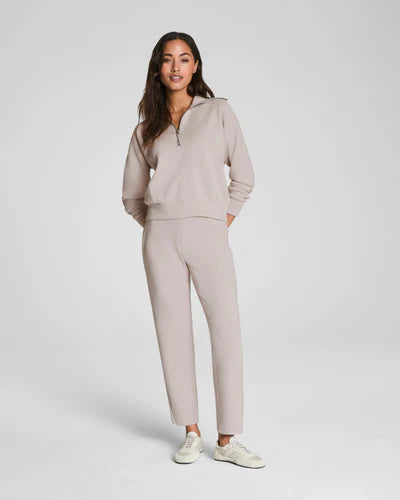 Woman wearing a beige tracksuit on a white background