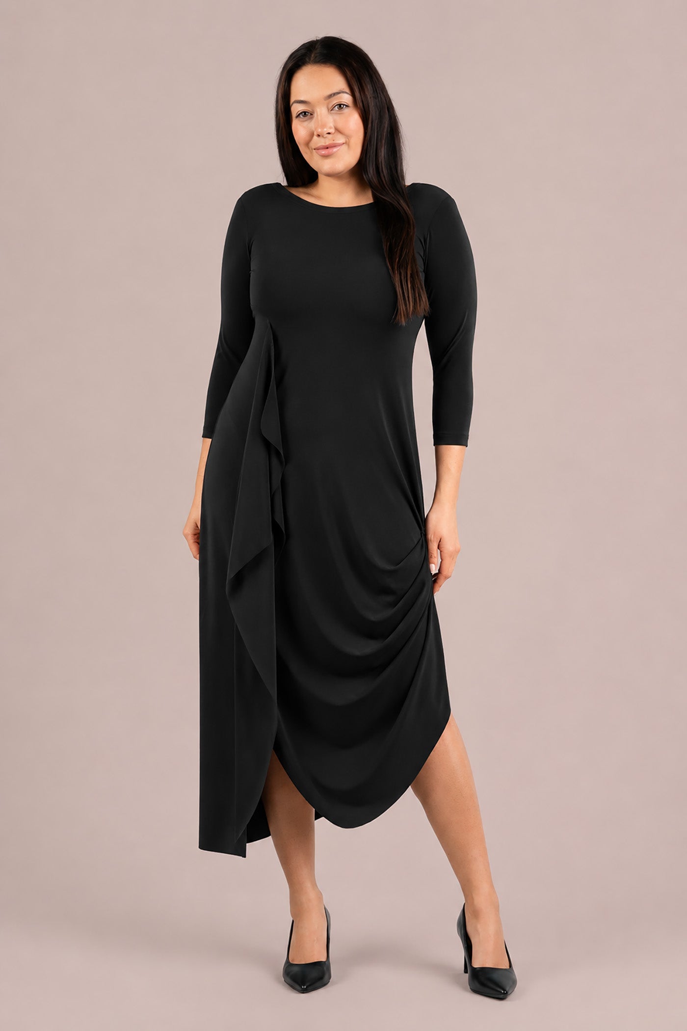 A woman modeling a black three-quarter sleeve midi dress with draped side detail and a high-low hem Sympli Drama Dress 3/4 Sleeves in Black
