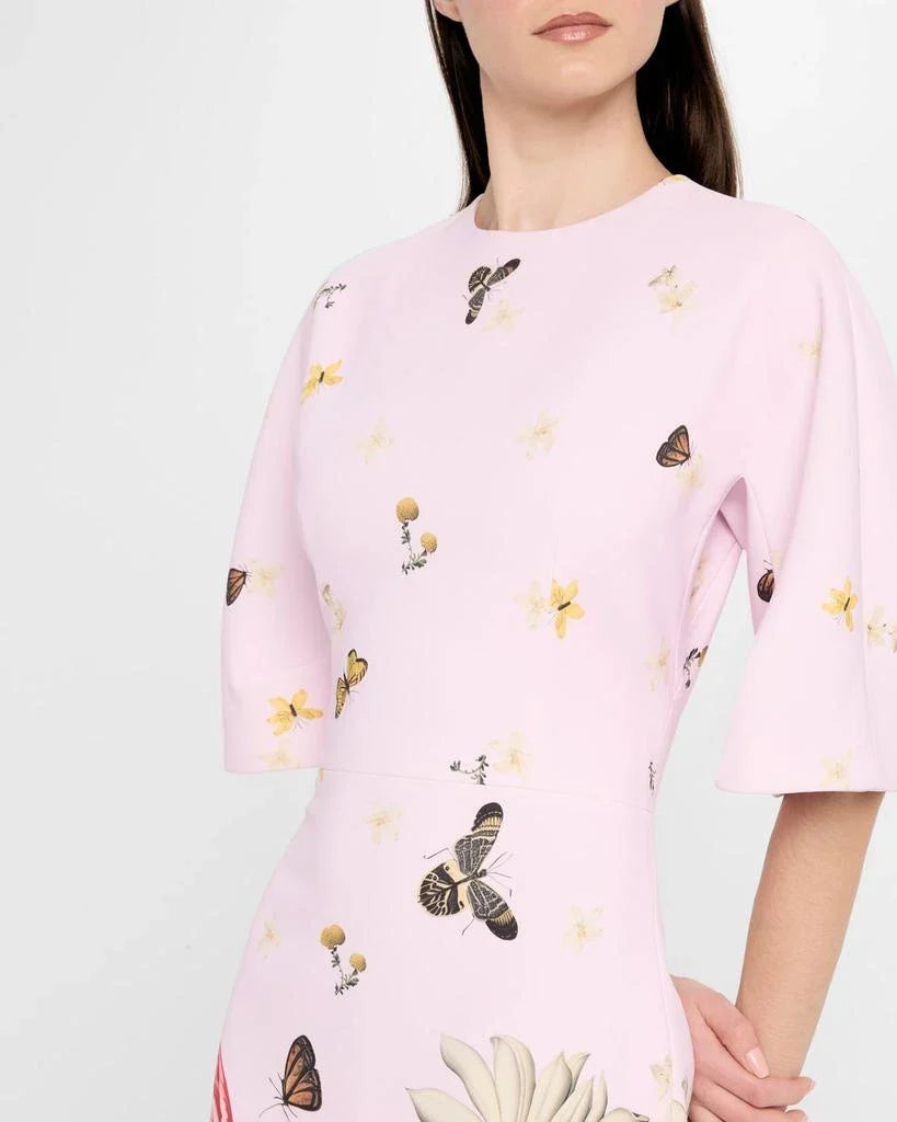 Pink blouse with butterfly and floral patterns worn 