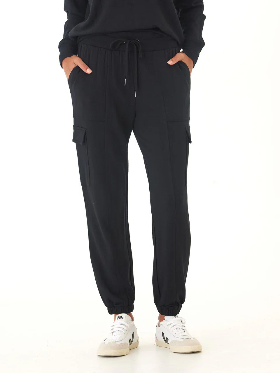 Person wearing black cargo jogger pants on a white background