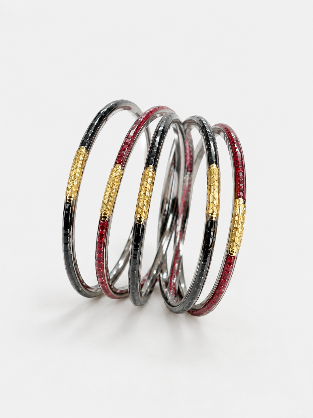 Five stacked bangles with a textured black and silver outer layer and a central gold band inlaid with red stones, UGA Color-Filled Bracelet Set