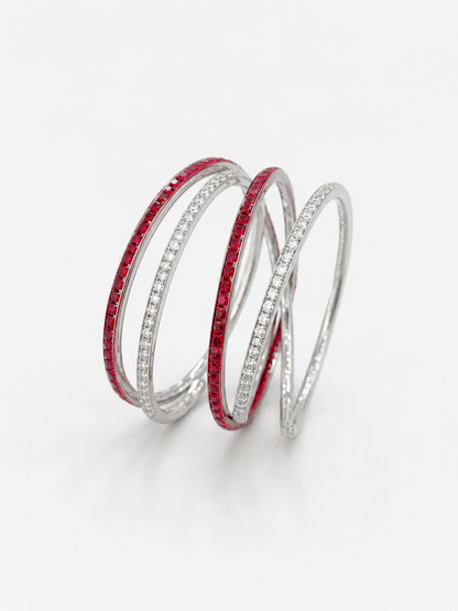 A set of five overlapping silver bangles, featuring two adorned with vibrant red gemstones and one with clear pavé-set stones UGA Color-Filled Bracelet Set