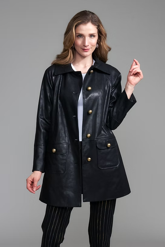A woman modeling a black leather coat with gold-tone buttons by insight Vegan Leather Car Coat